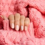 pretty-nude-color-manicure-one-finger-shiny-golden-knitted-pink-wool-pillover-background-scaled-1.jpg